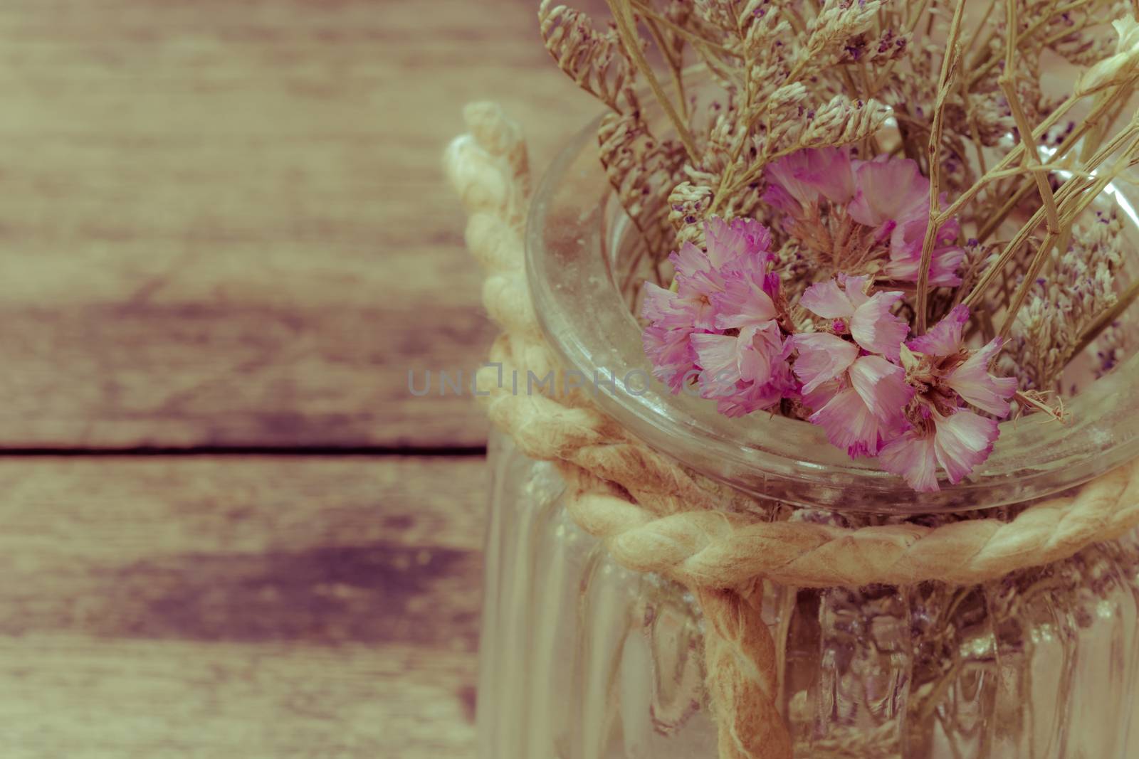 closeup dried flowers in glass jar on blurred wooden table, copyspace, retro style.