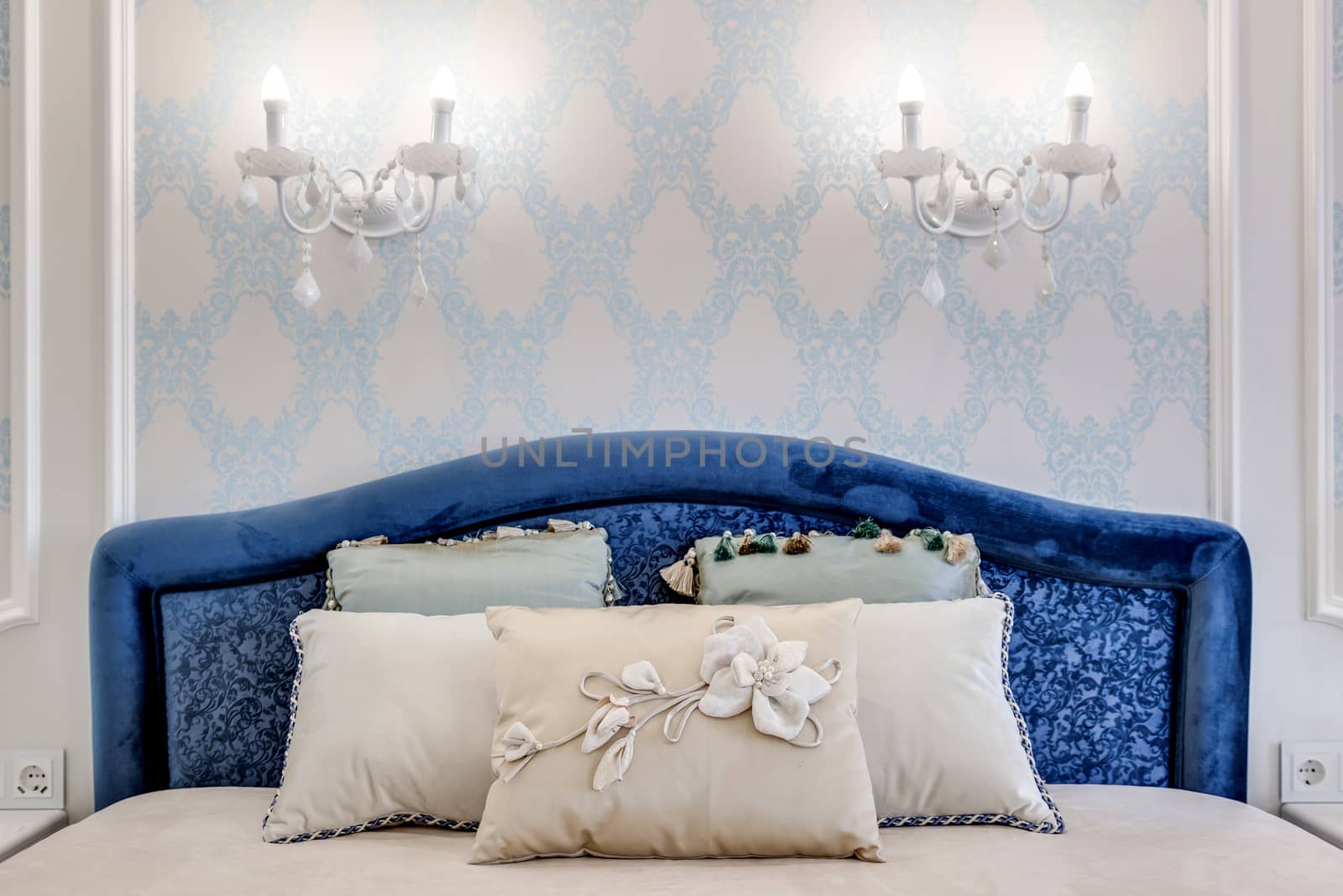Headboard With decorative pillows and a candelabra over the bed