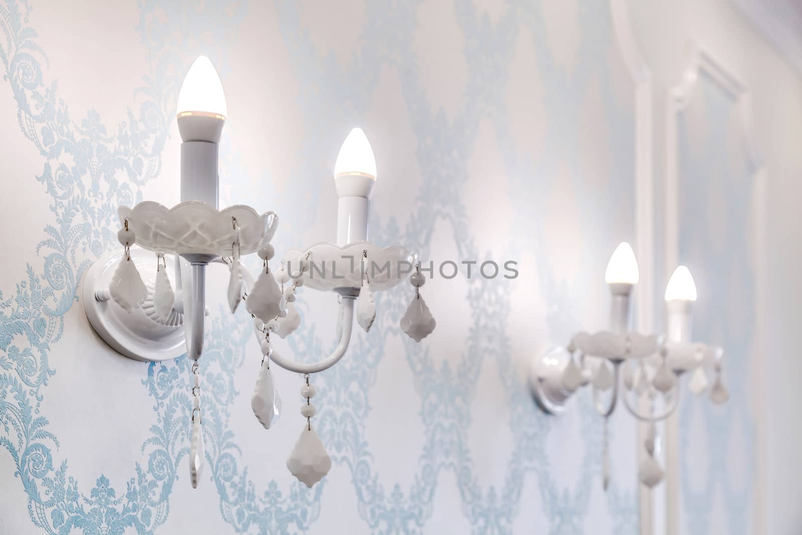 Vintage candelabra with lamps on a beautiful wall by sveter