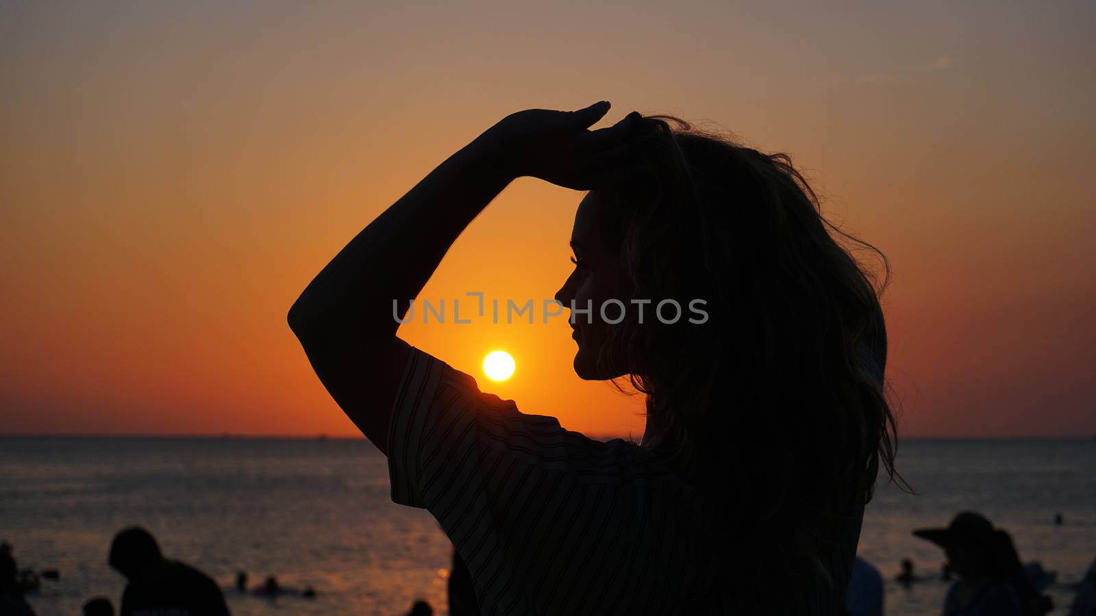 Side view of back light of a woman silhouette warm sunset in front of sun - tourist beach at sunset