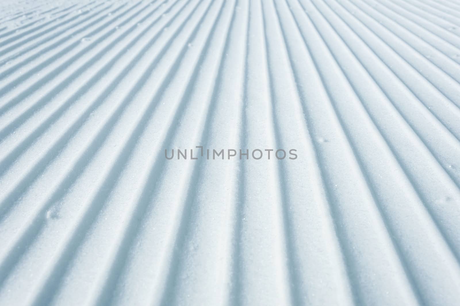 Geometry track lines on a ski slope left by a snowcat as a texture background.