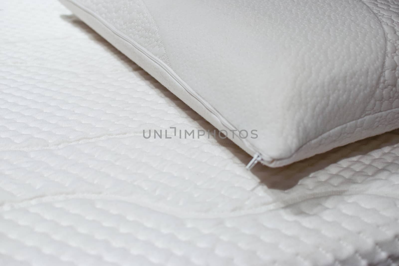 Modern and healthy bed with white mattress and pillow in close-up.