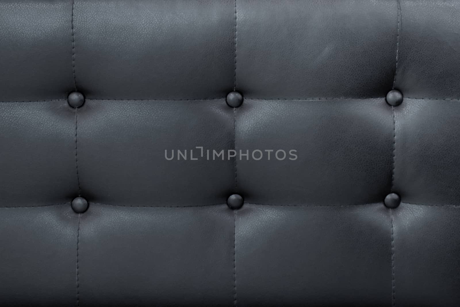 Luxury black leather sofa with buttons background.