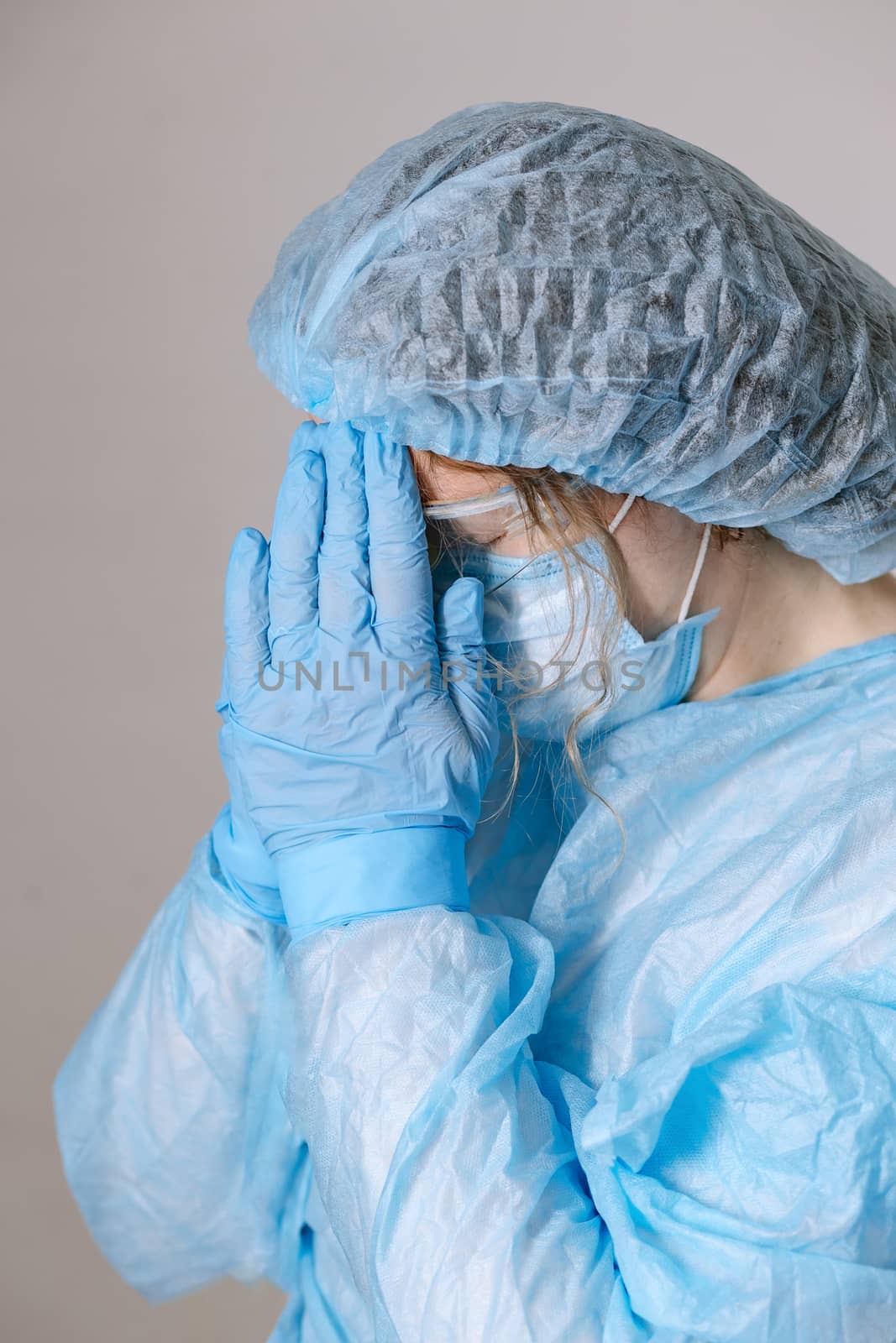 Praying tired doctor. Tired praying nurse at the hospital. The fight against the disease, viruses. A doctor, a nurse who is thinking about treating a disease and a pandemic. Surgeon after surgery.