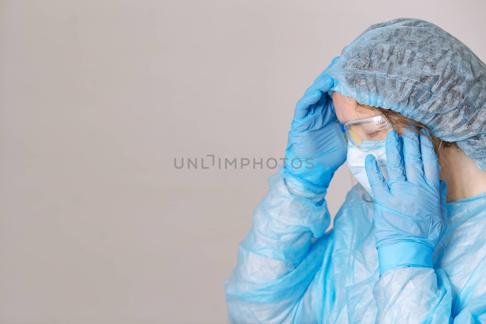 Praying tired doctor. Tired praying nurse at the hospital. The fight against the disease, viruses. A doctor, a nurse who is thinking about treating a disease and a pandemic. Surgeon after surgery.