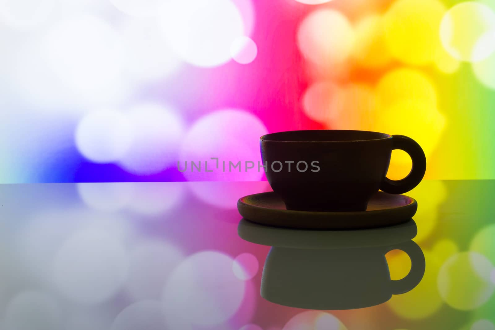 horizontal photo of silhouette coffee cup on colorful bokeh background.