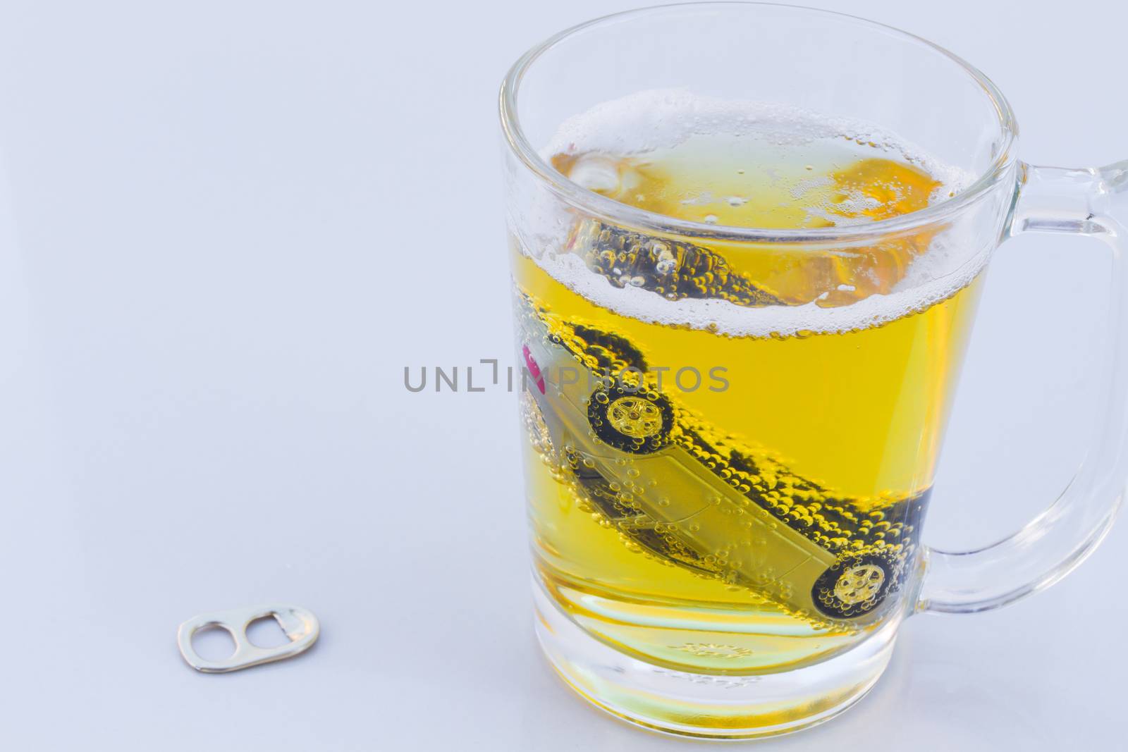 horizontal photo of toy car in a glass of beer isolated on white background. Drunk-driving Prevention Concept.