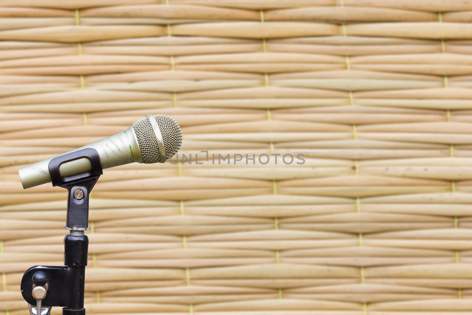 side view of microphone on blurred texture of Thai styled weave mat, background