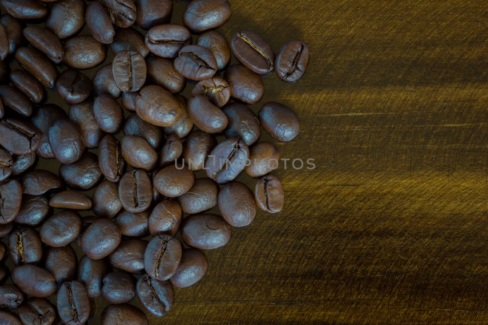 extreme closeup coffee beans on wooden background, dark tone. Top view.