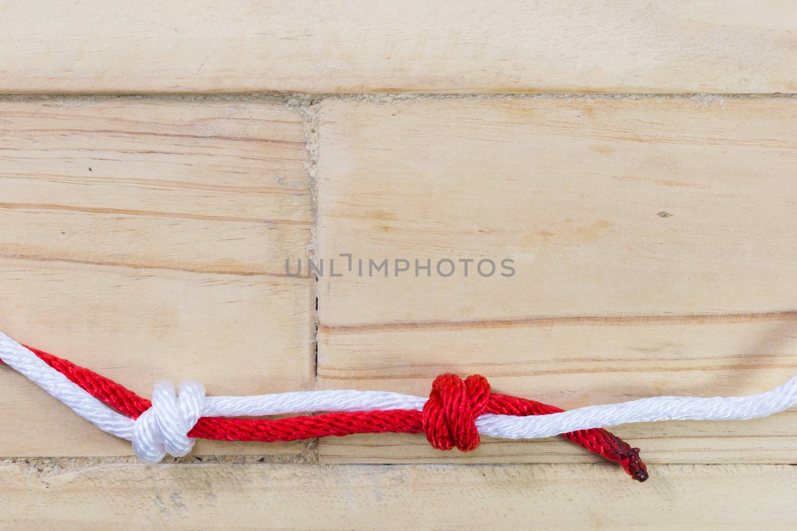 fisherman's knot made with red rope on wooden background