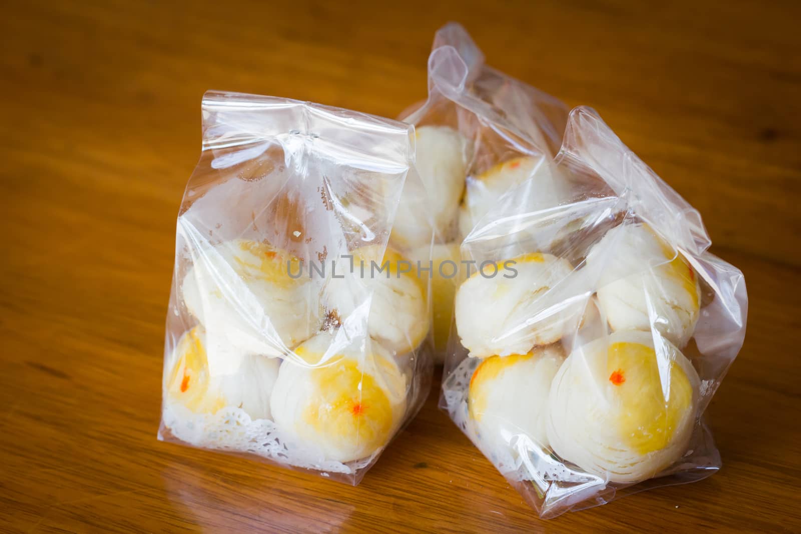 Traditional Chinese cake in plastic bag on wooden background