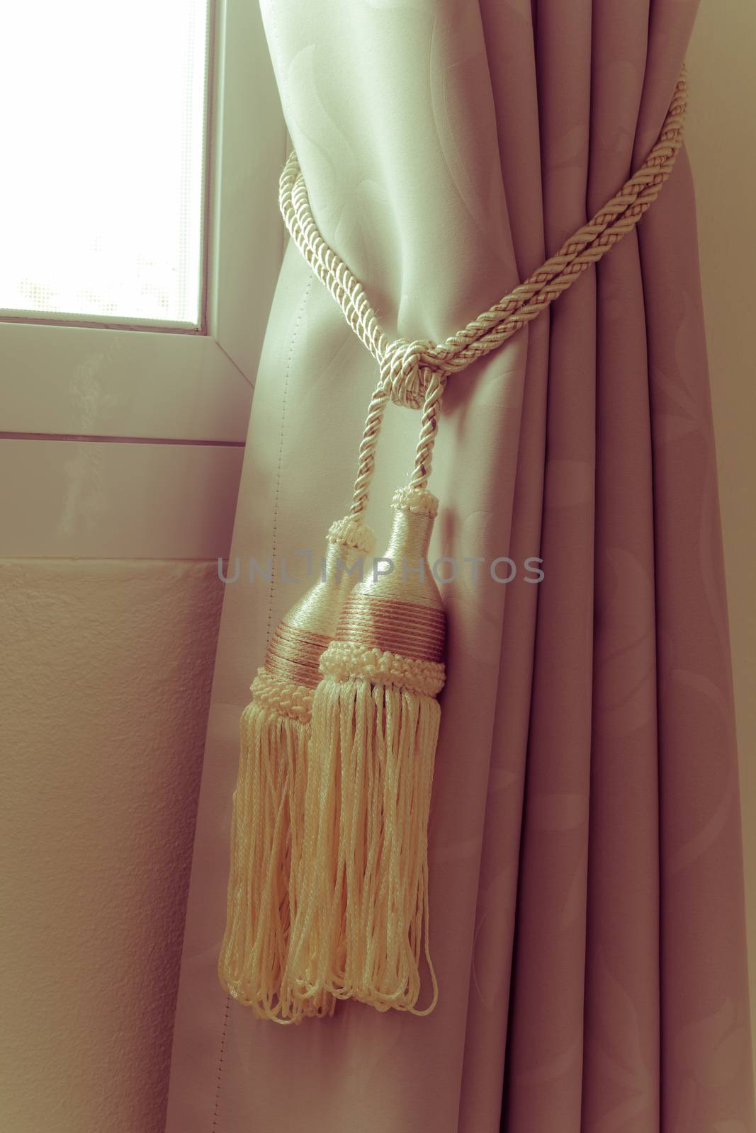 Curtains tassel with rope by the window on the left, vintage retro style.