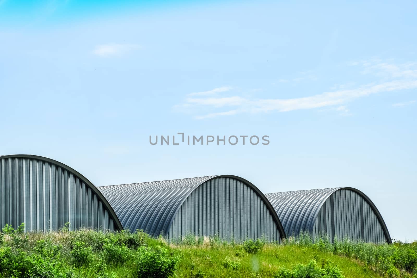 Large hangars made of galvanized corrugated sheet iron.