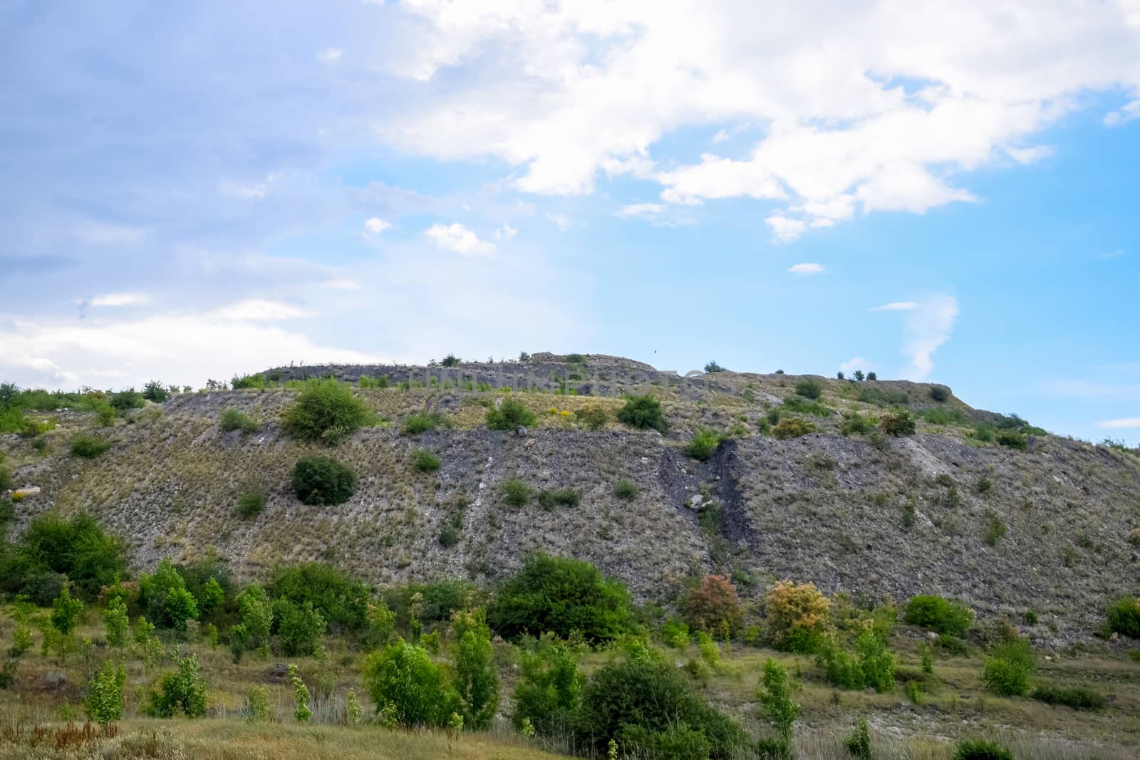 ore slag dumps after processing. Old stepped terricon in the form of a hill with terraces