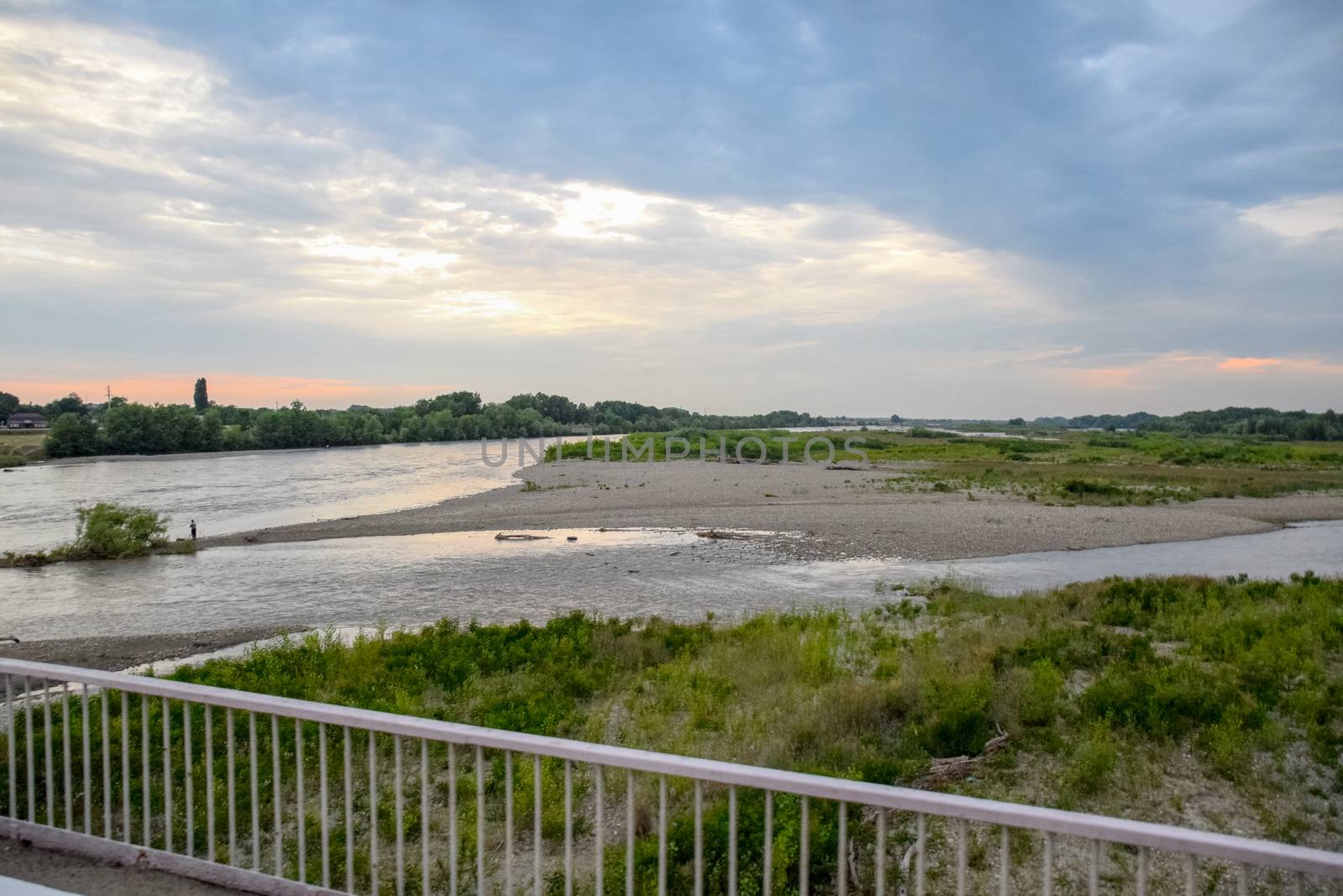 Passing over the bridge over the river. The landscape of the river, the surface and the trees of the river's waterplain.