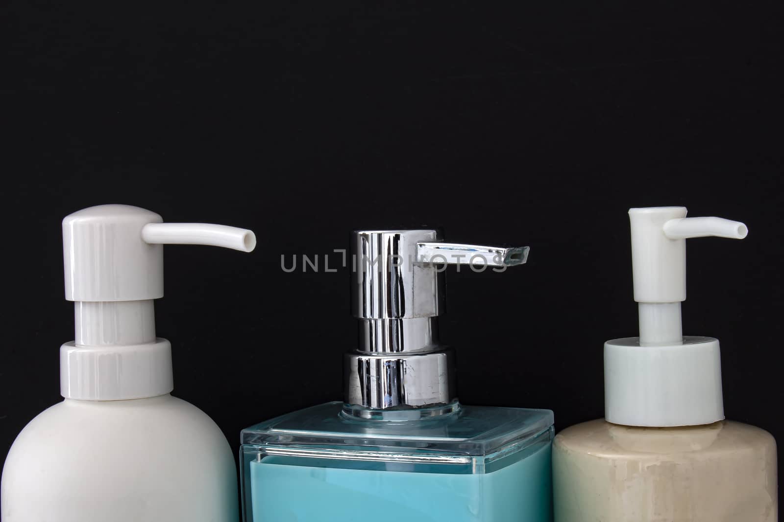 Close up top view of colorful soap dispenser for bathrooms or kitchen sinks on a black background