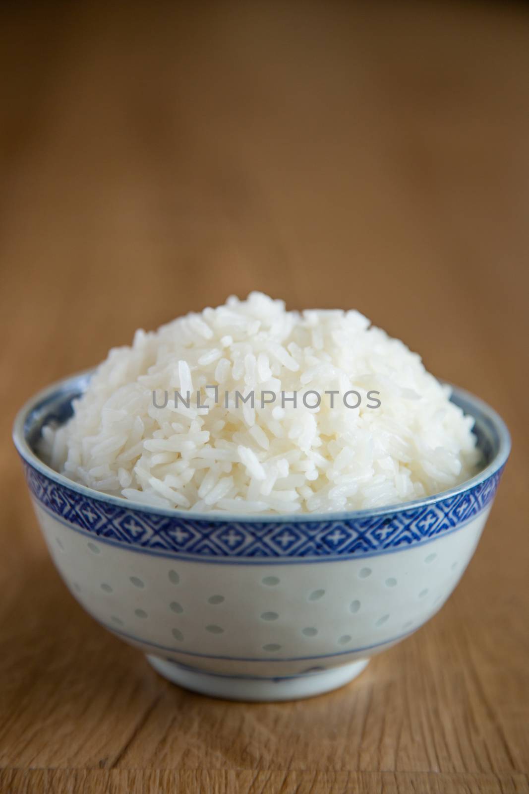 a bowl of white rice on wooden background