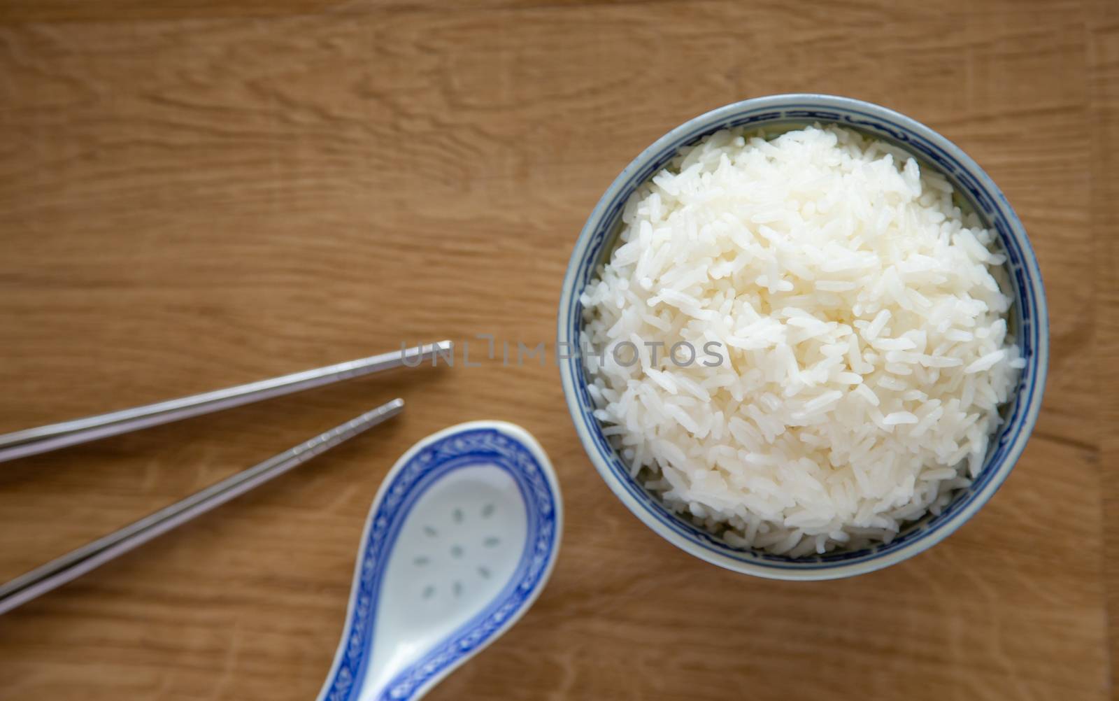 a bowl of white rice on wooden background