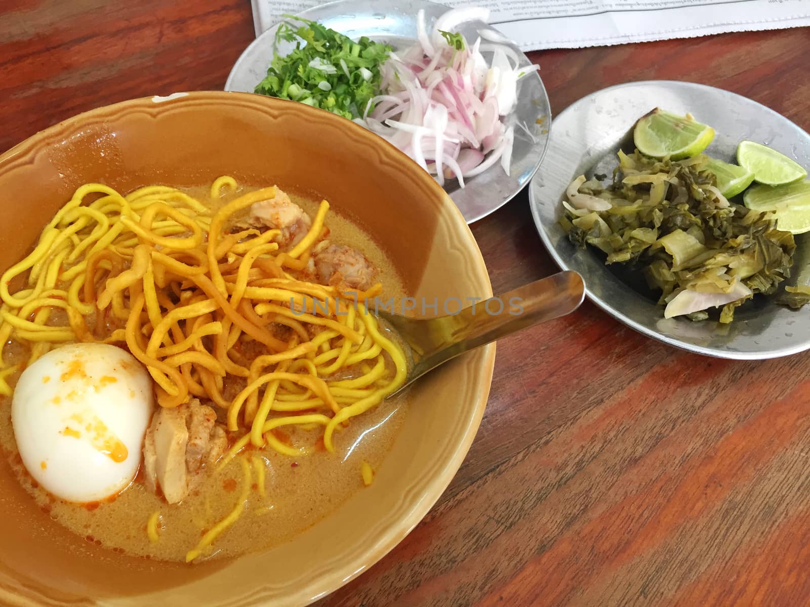 Curried Noodle Soup (Khao soi) with hard boiled egg. Horizontal photo