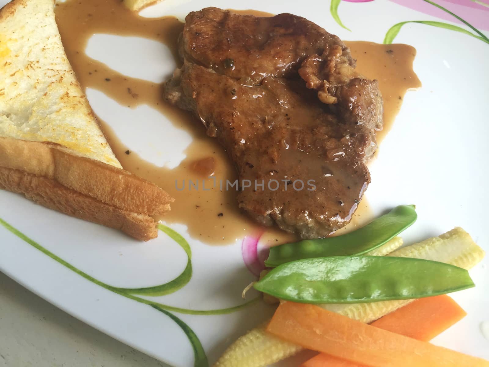 Rustic grilled pork steak with boiled vegetable. horizontal photo