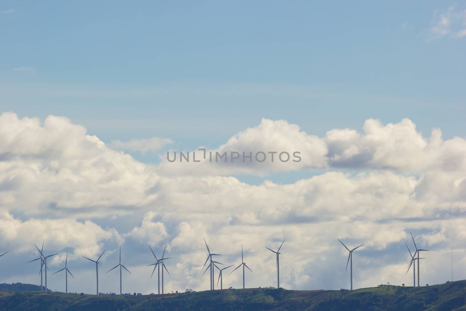 Wind turbines generating electricity on the top of the mountain, wide shot