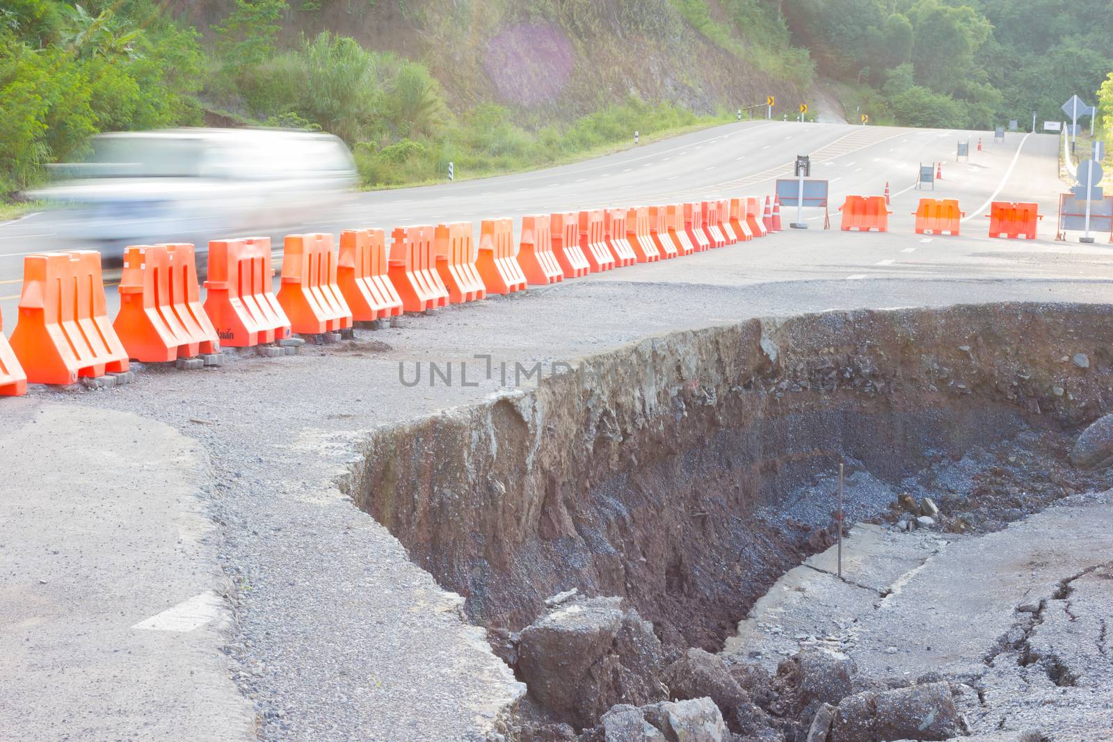 cracked road after earthquake with yellow barricade