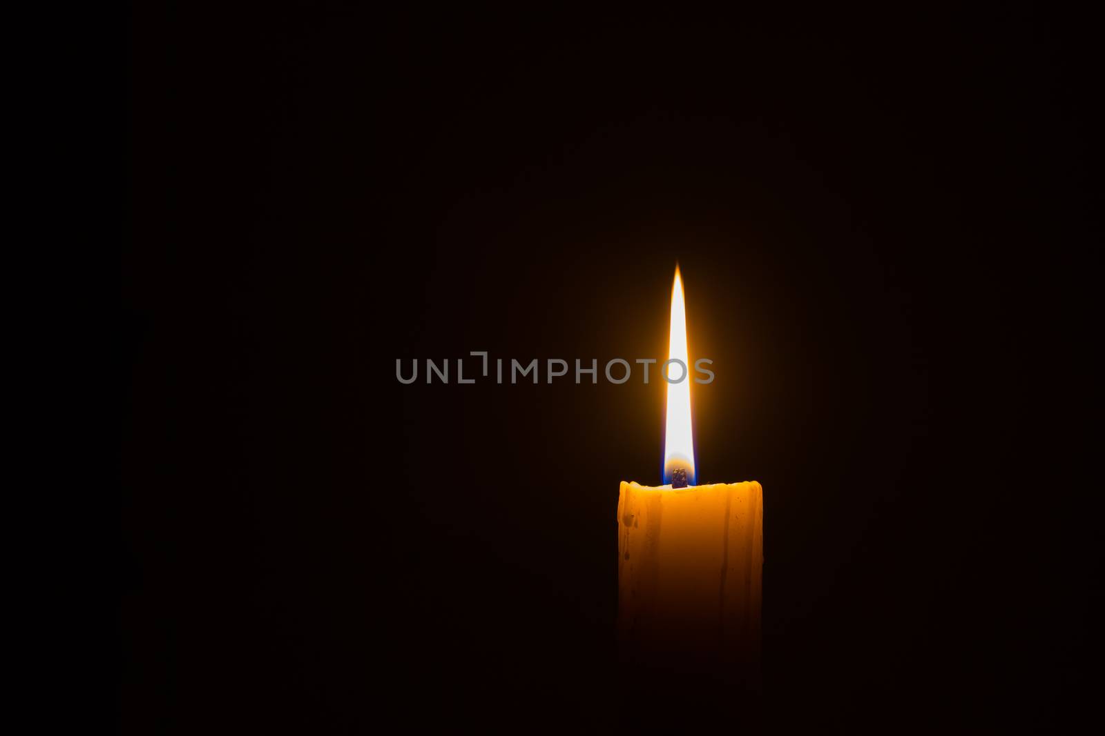 horizontal photo of candle on black background with copyspace