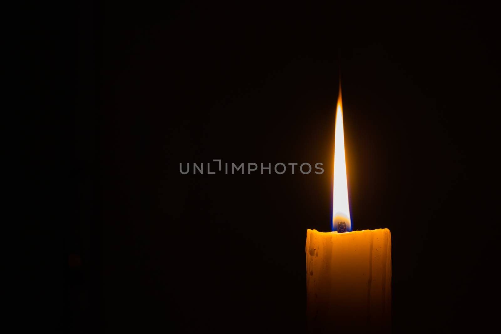 horizontal photo of candle on black background with copyspace