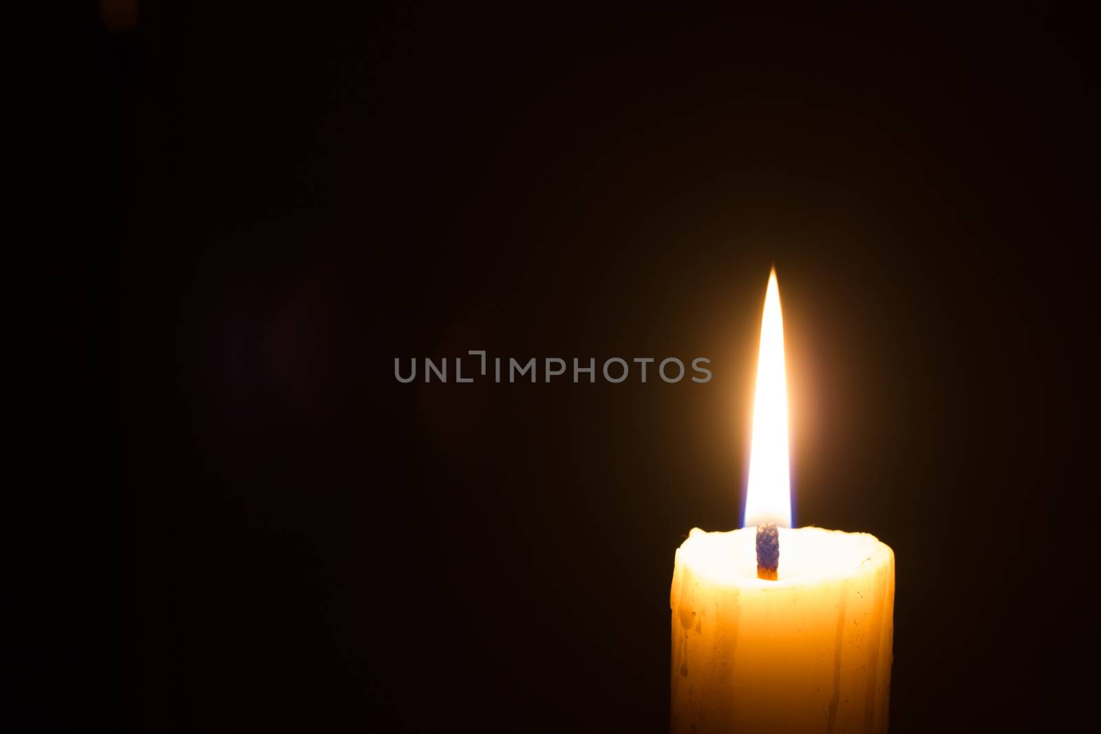 horizontal photo of candle on black background with copyspace