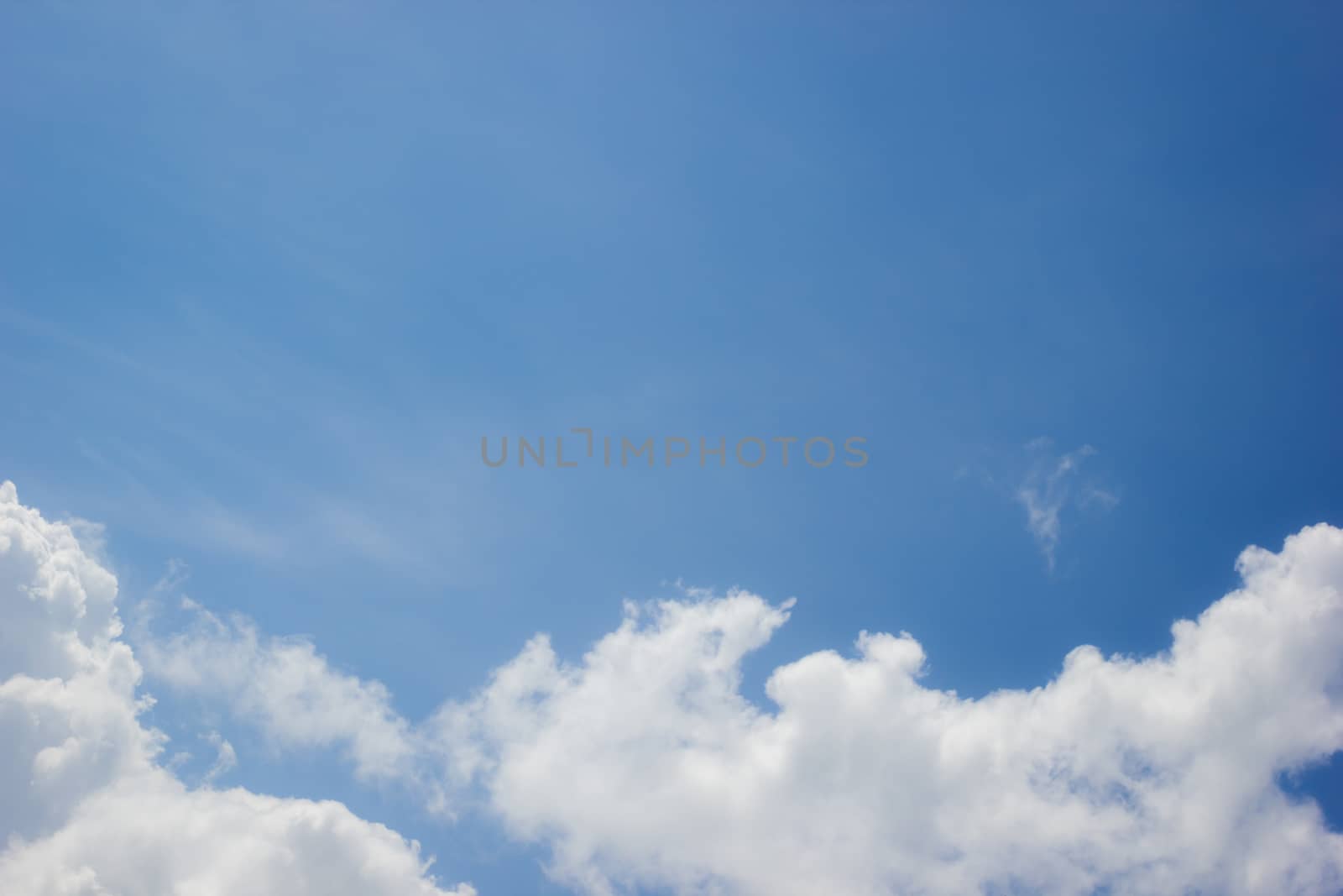 horizontal photo of clouds in blue sky with copyspace in the middle