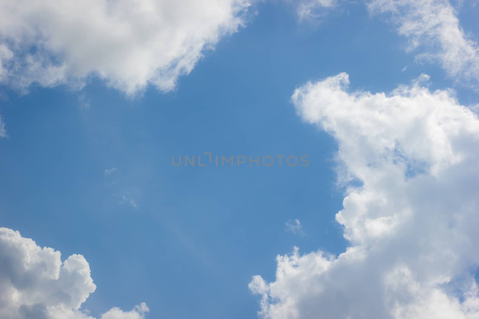 horizontal photo of clouds in blue sky with copyspace in the middle