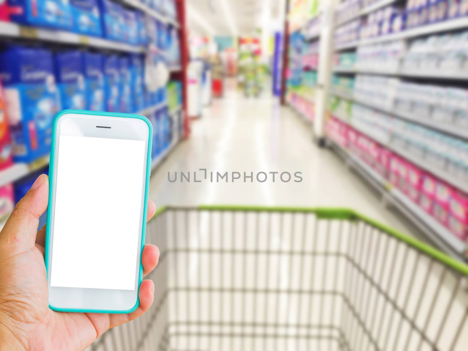 left hand holding green mobile phone with supermarket blur background, online shopping concept.