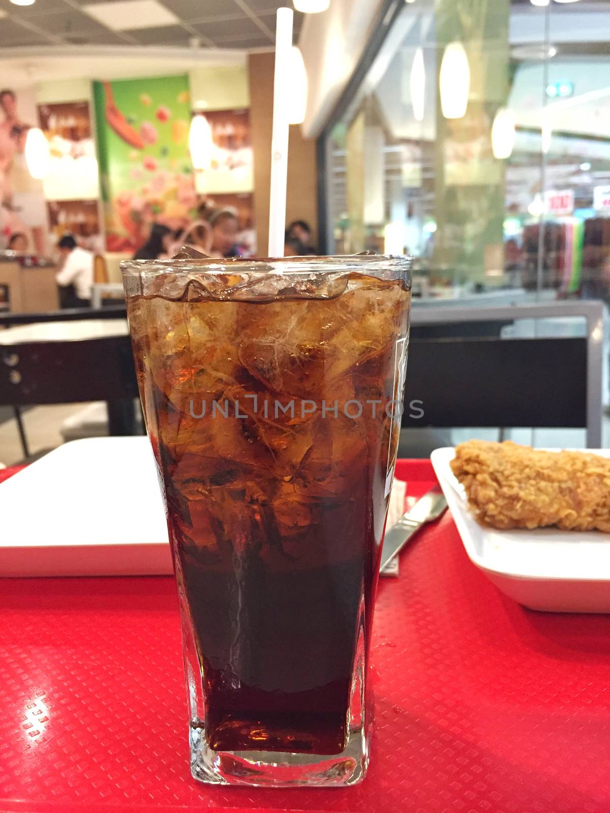 Iced cola with shallow depth of field blurred restaurant background