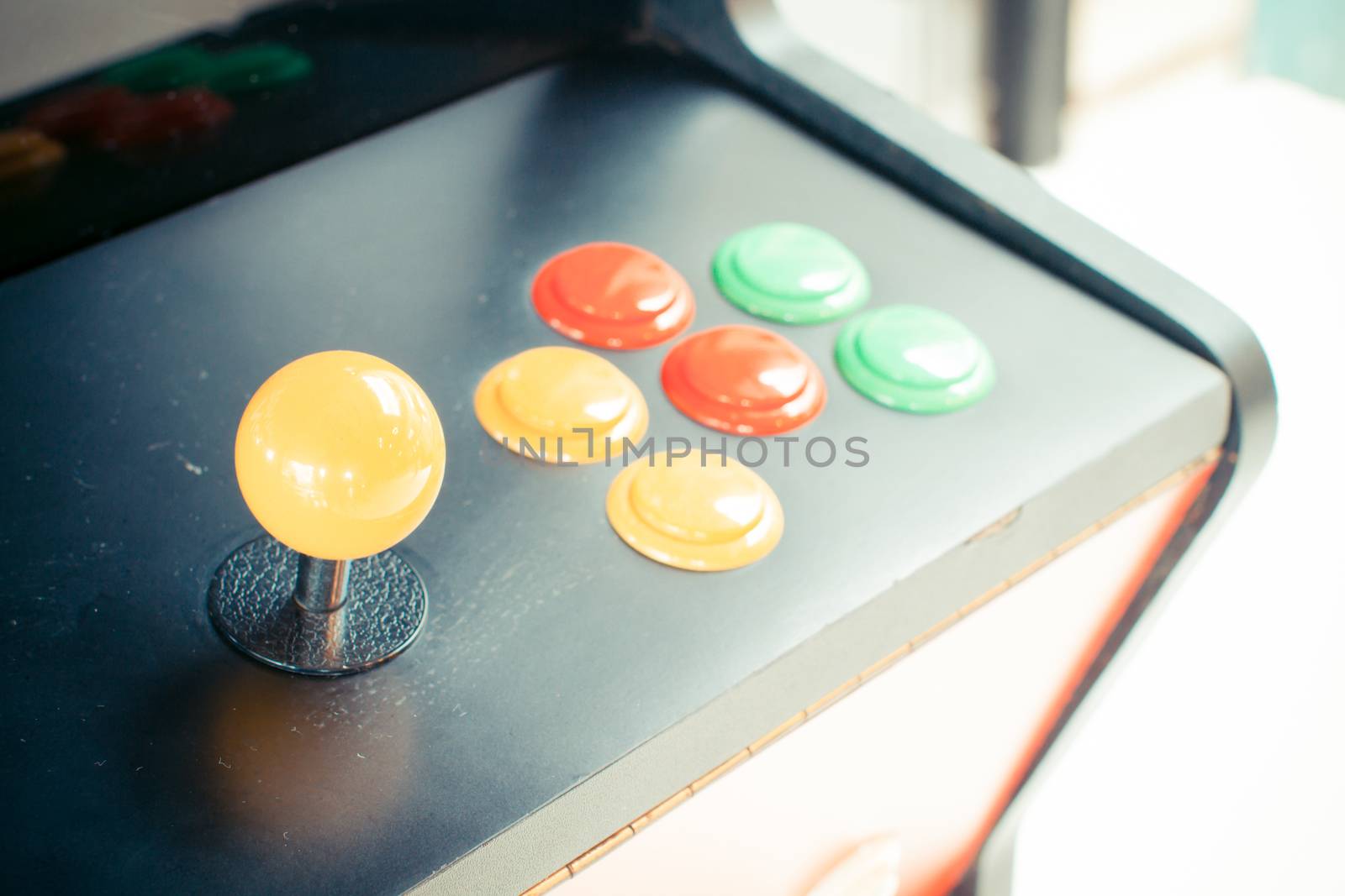 yellow joystick of an old arcade video game with six colorful button. Copyspace. Retro filter.