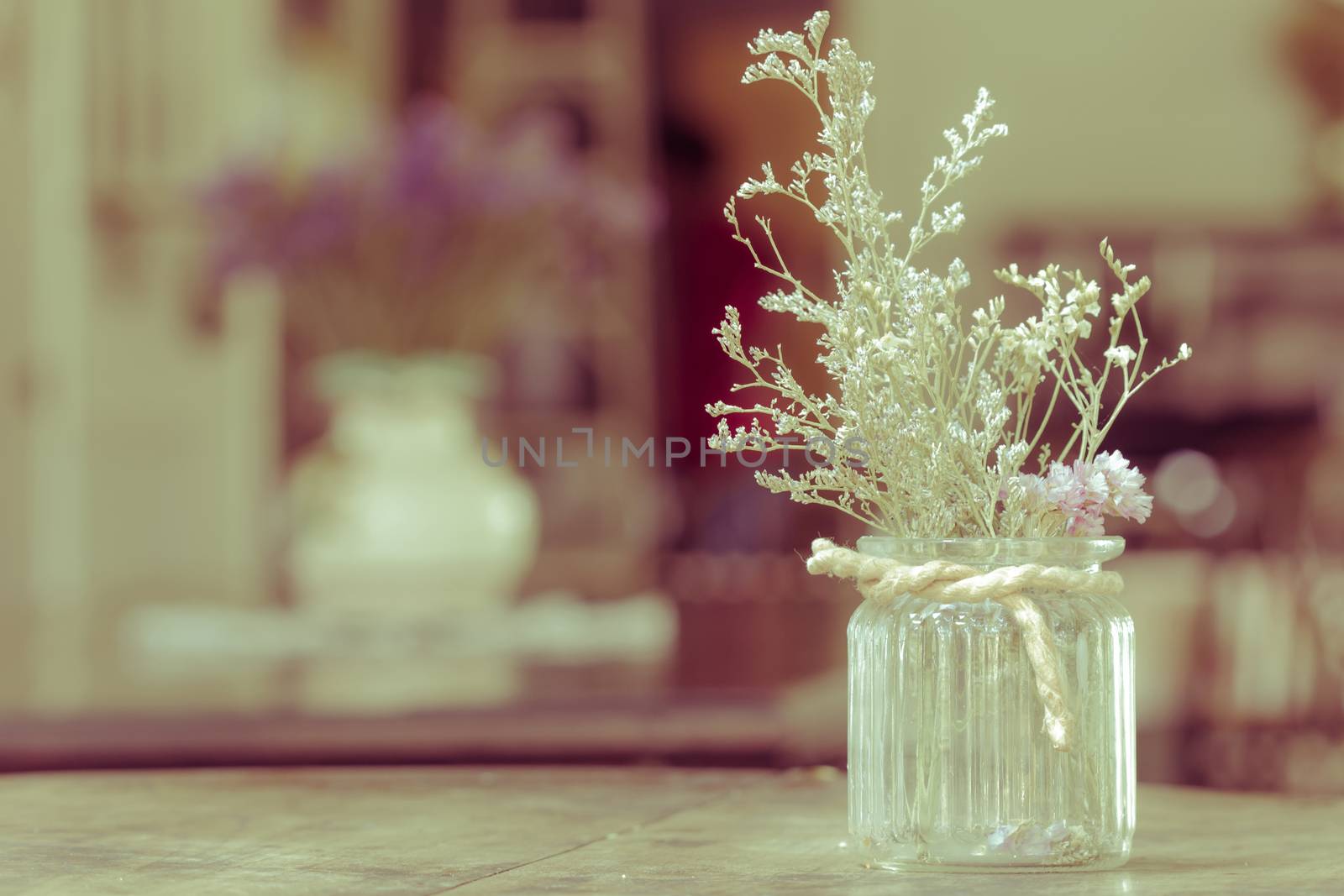 dry flowers in glass vase with rope on blurred background, copyspace. Vintage retro style.