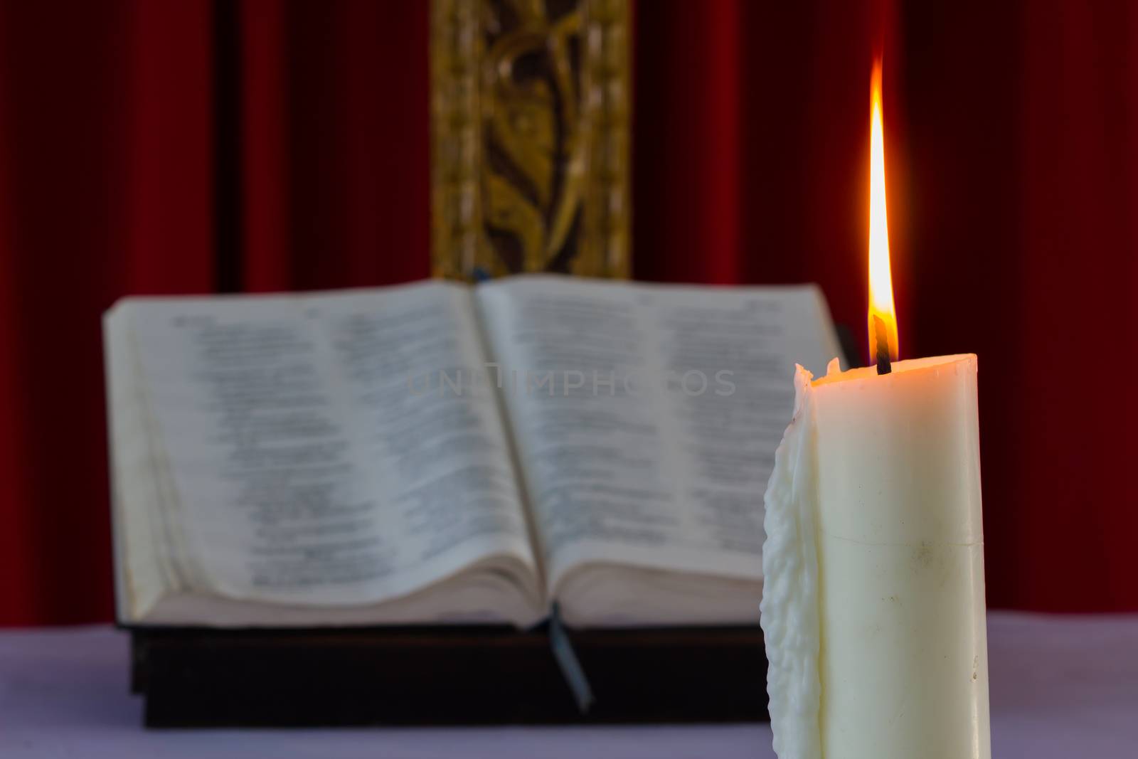 candle light with over open bible book in the night