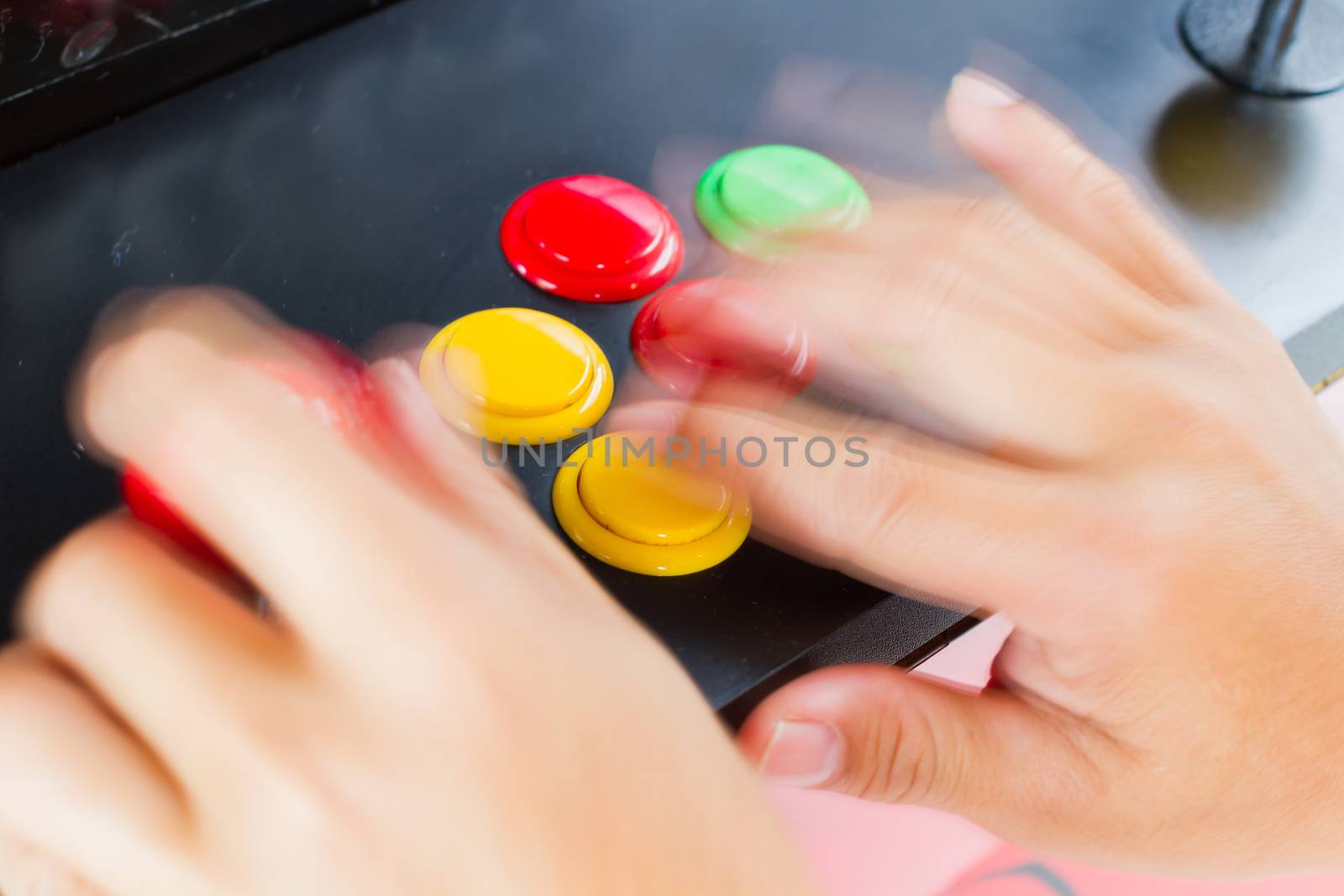 close-up blur hands with movement pressing and holding joystick of old arcade video game