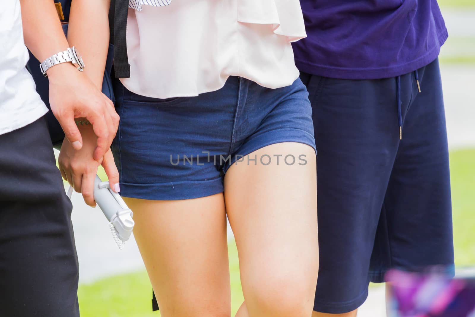 Close-up of walking asian woman wearing denim shorts blue jeans