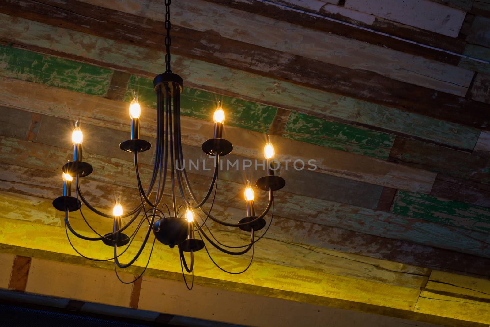 lighting bulbs on the chandelier hanging from the wooden ceiling. Copyspace