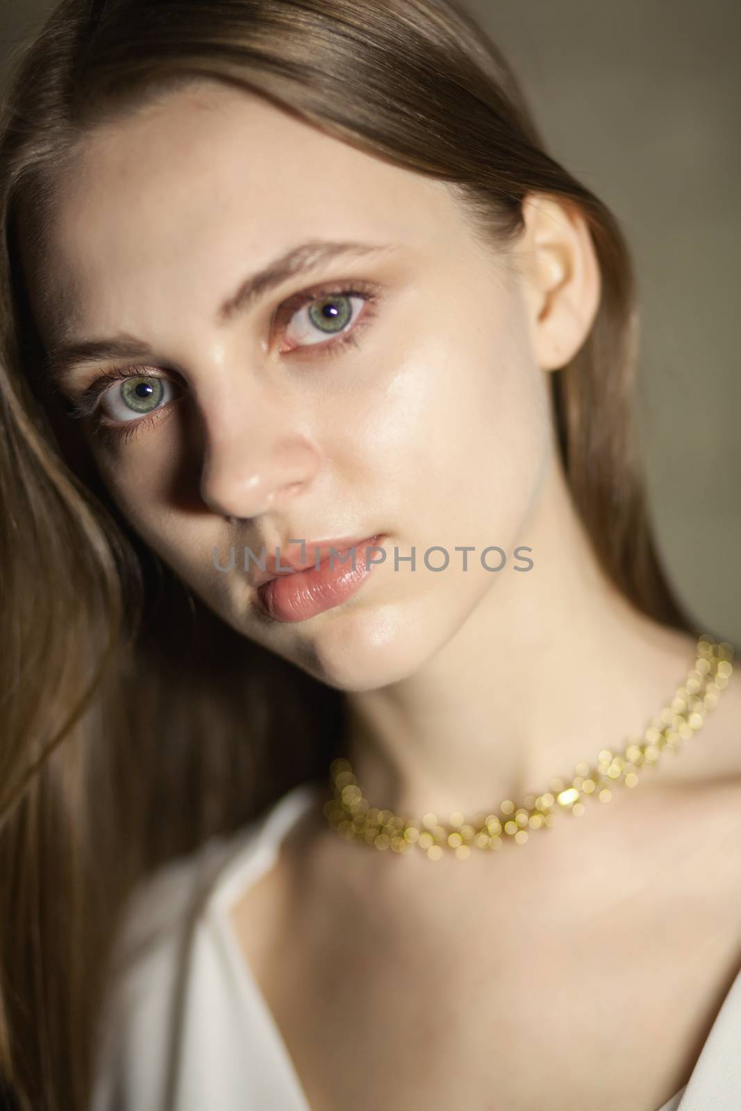 Portrait of beautiful fair young woman with fashion jewelry, one light source