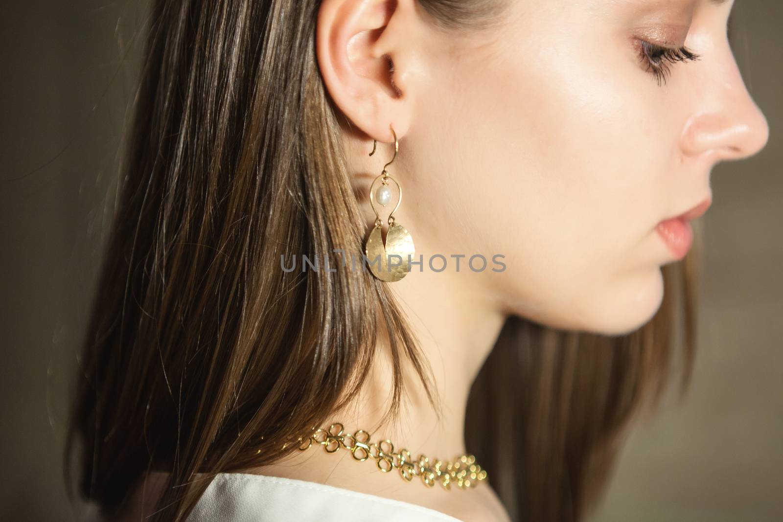 Portrait of beautiful fair young woman with fashion jewelry, one light source