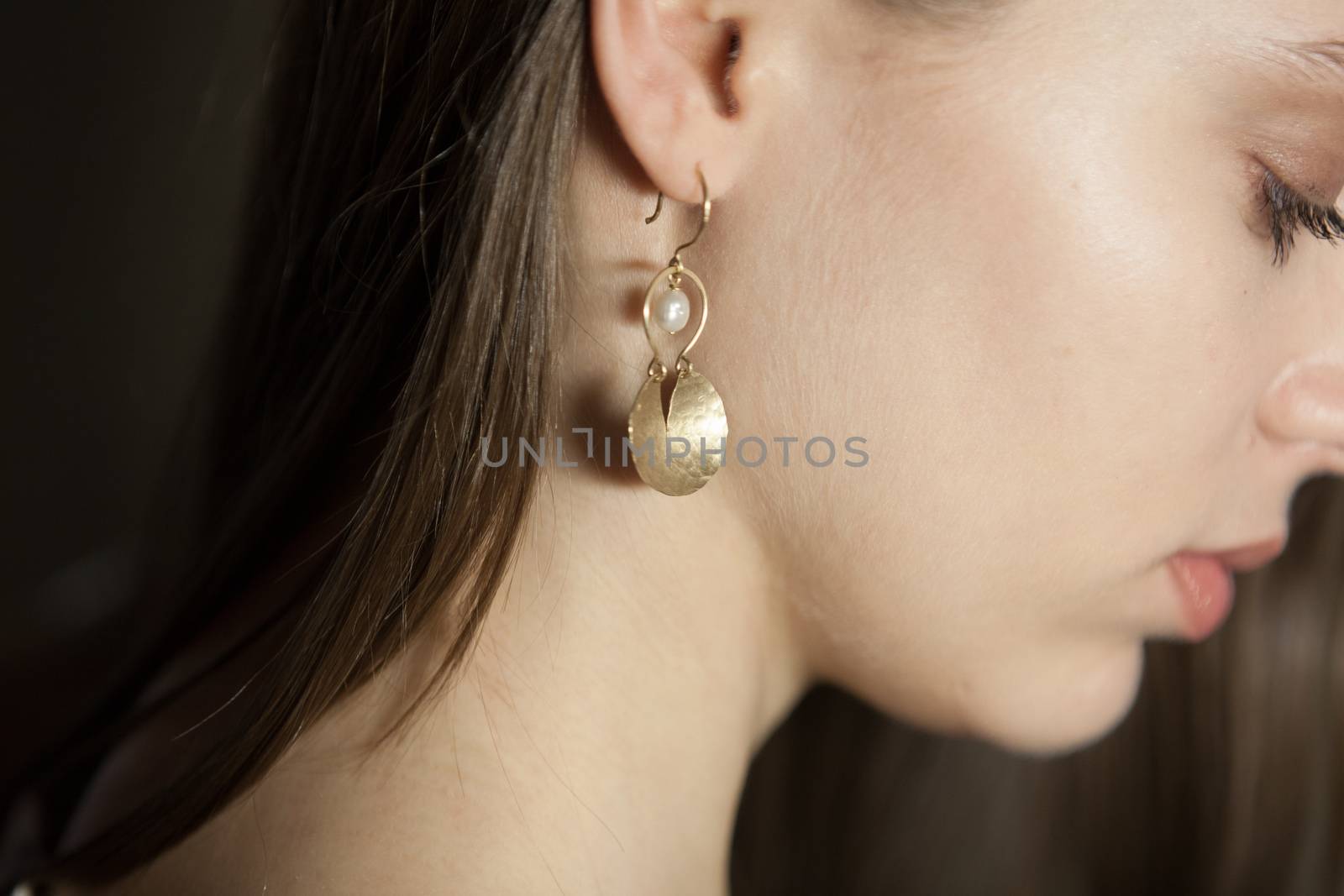 Portrait of beautiful fair young woman with fashion jewelry, one light source