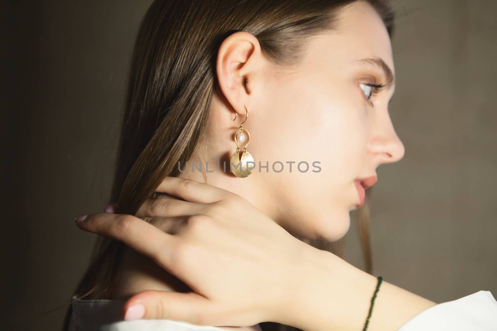 Portrait of beautiful fair young woman with fashion jewelry, one light source