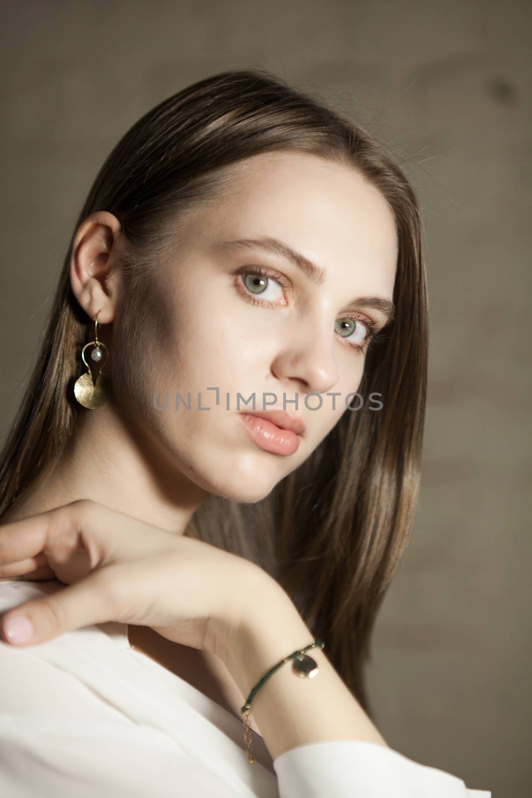 Portrait of beautiful fair young woman with fashion jewelry, one light source