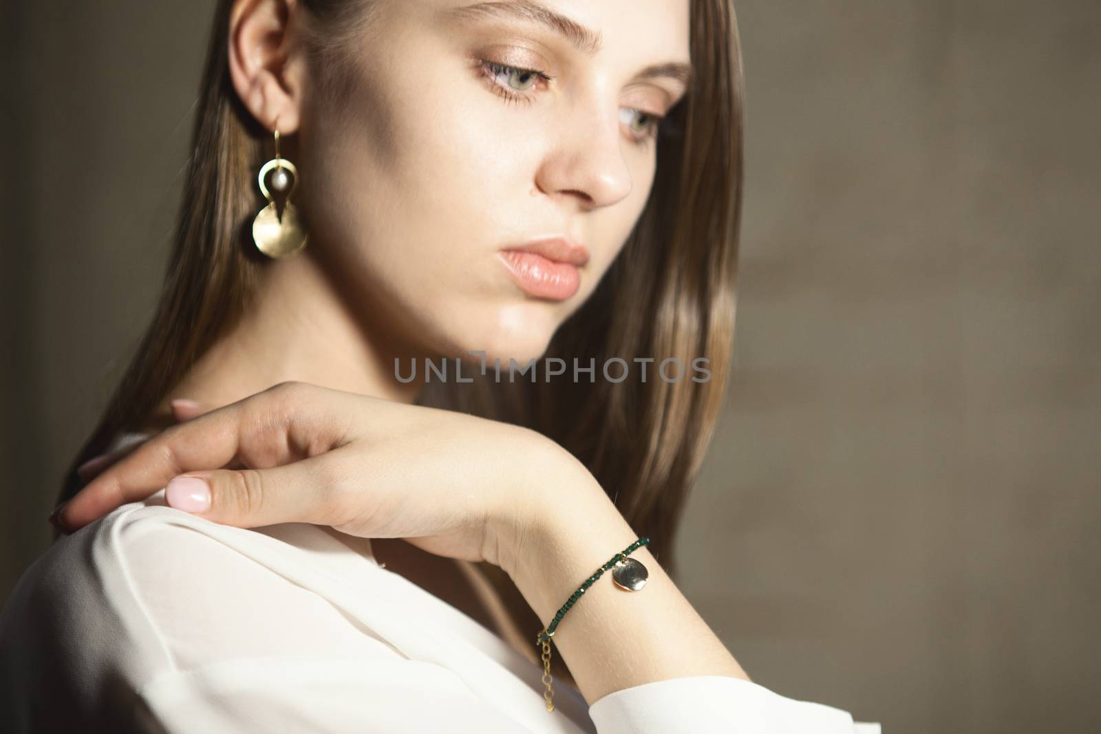 Portrait of beautiful fair young woman with fashion jewelry, one light source