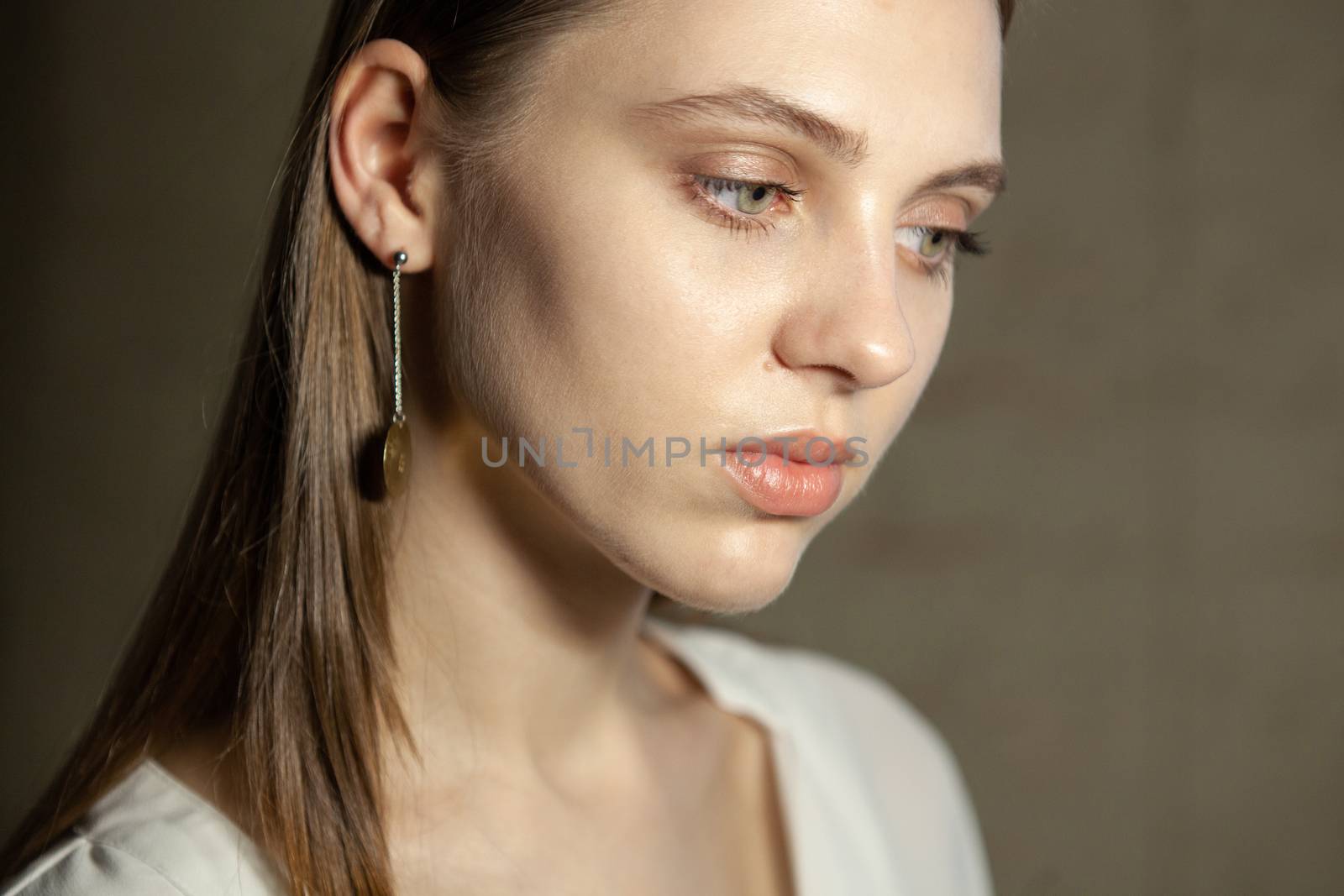Portrait of beautiful fair young woman with fashion jewelry, one light source