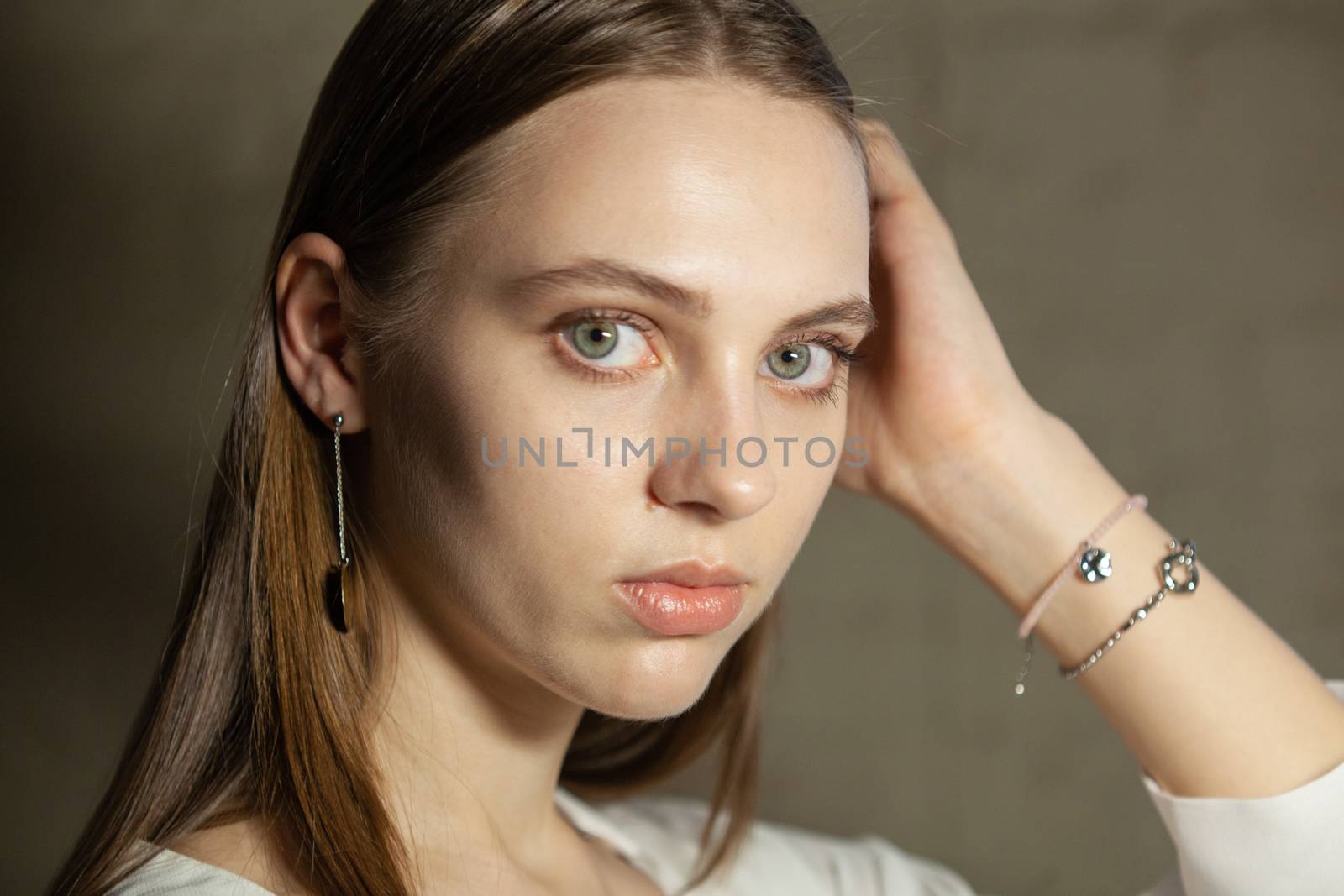 Portrait of beautiful fair young woman with fashion jewelry, one light source