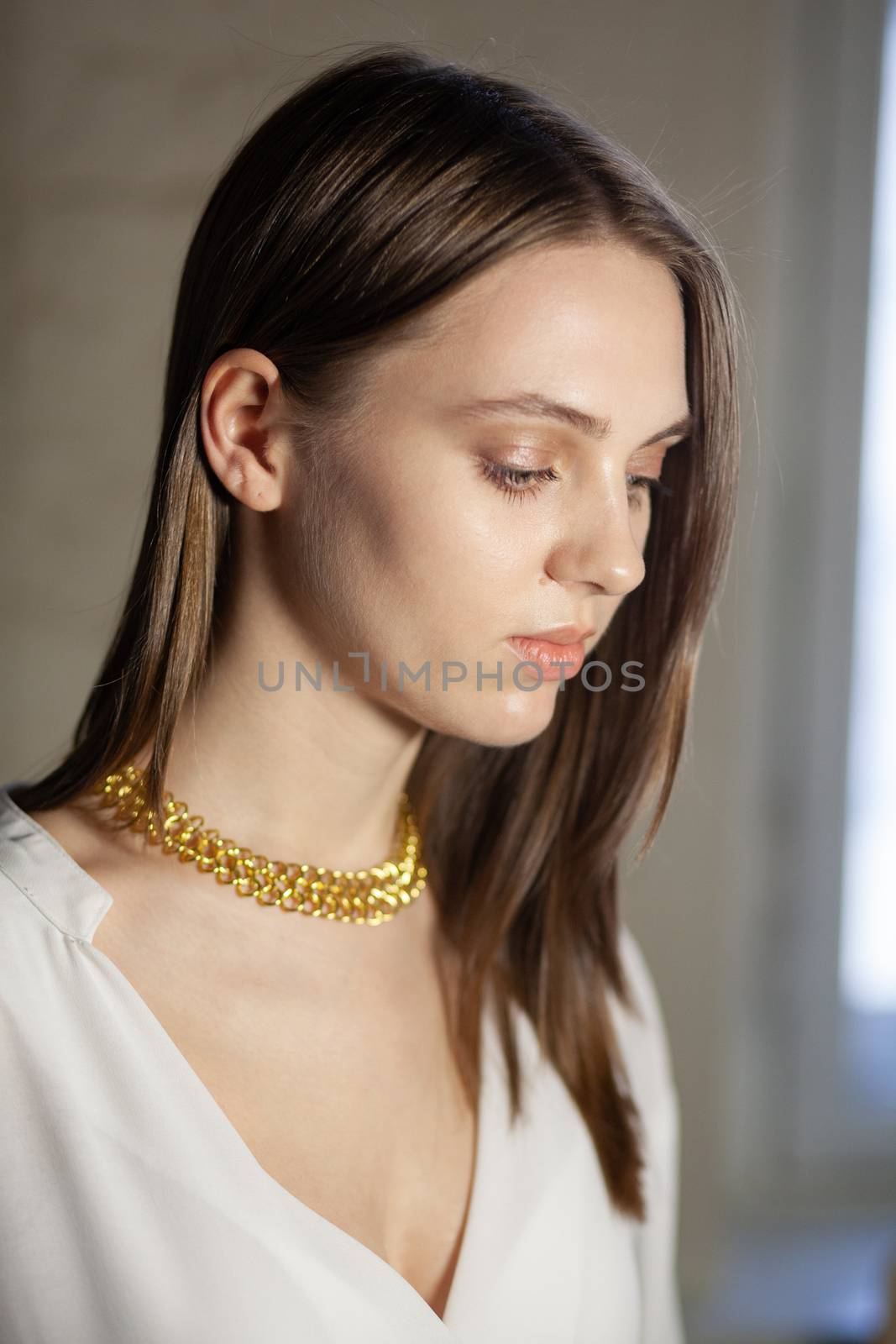 Portrait of beautiful fair young woman with fashion jewelry, one light source