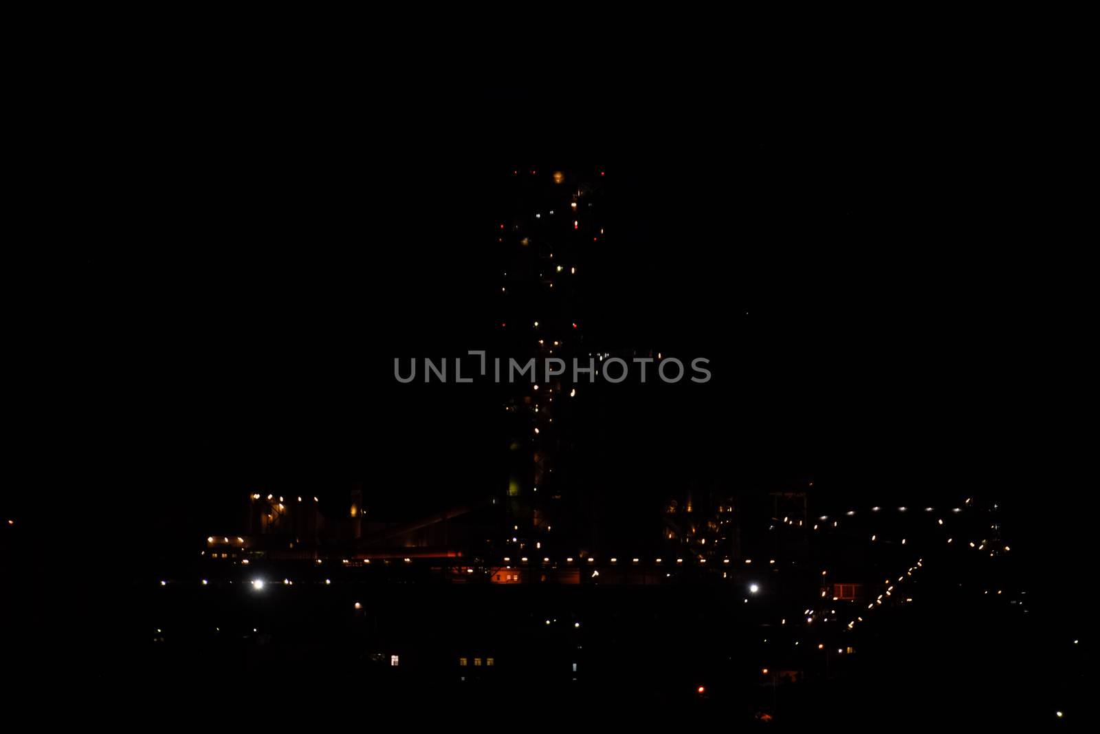 The building of a cement plant at night, the lights of a lamp lighting a factory. Industrial facility.