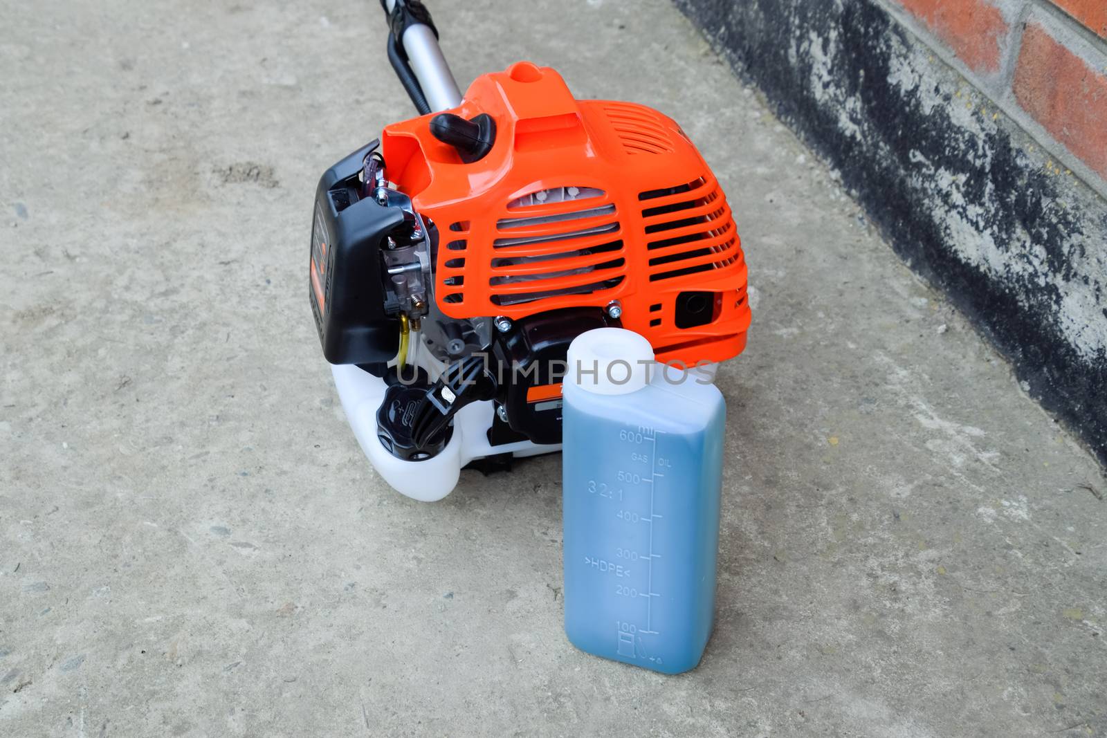 Prepared fuel mixture for a two stroke gasoline trimmer engine. Gasoline trimmer. Trimer gascosis with a leaf for mowing grass and shrubs.